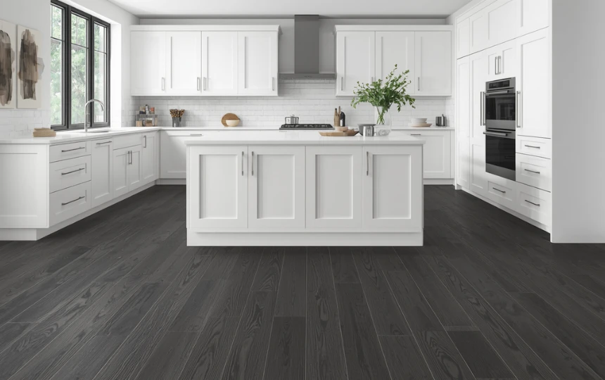 Modern white kitchen with bright white cabinets dramatically contrasted against dark charcoal hardwood floors